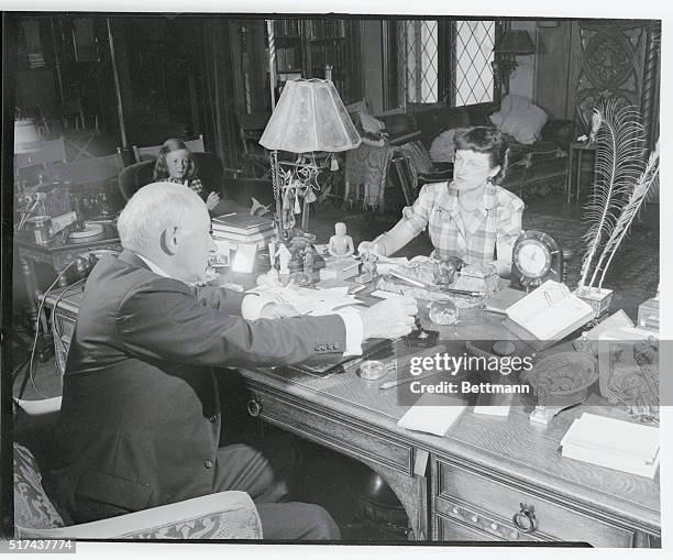 Here is director producer Cecil B. DeMille at work in his business office, assisted by his private secretary Gladys Rosson. In the corner at left is...