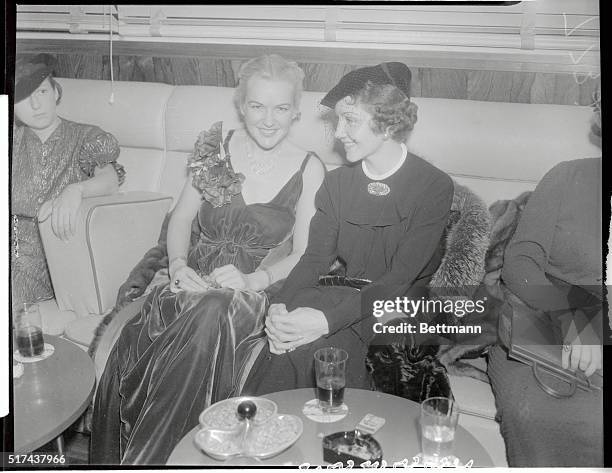 Eadie Adams and Claudette Colbert, famous residents of the movie colony here, caught in an informal moment at the cinegrill of the Hollywood...