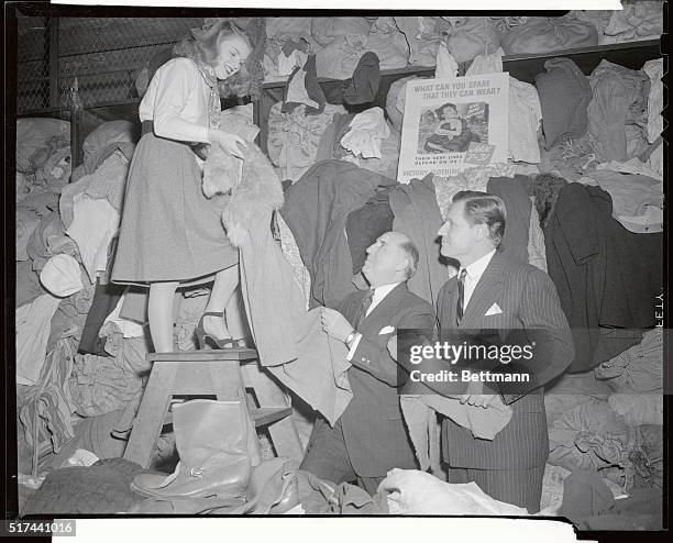 Pat Vaniver, who will reign as Queen of the Photographer's Ball, helps Postmaster Albert Goldman, , and Nelson A. Rockefeller sort some of the...