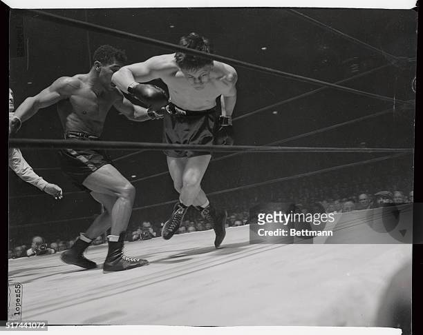 Morris Reif gets his legs all mixed up and is about to fall to the canvas under the powerful attack of Beau Jack in the fourth round, the knockout...
