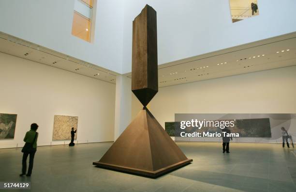 Visitors walk around a sculpture by Barnett Newman titled "Broken Obelisk" in the newly remodeled Museum of Modern Art during a media preview...