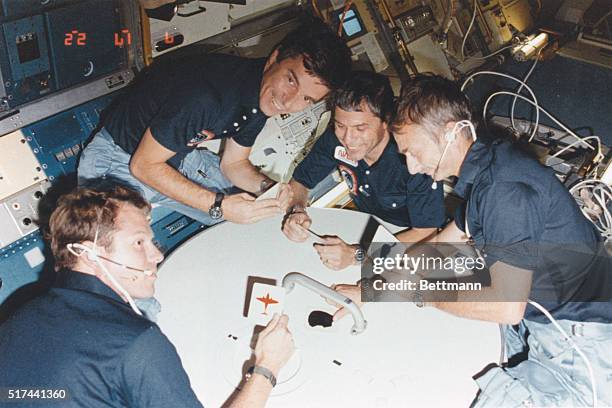 Earth Orbit: What appears to be a space card game is actually just four STS-9 crew enjoying a rare brief moment of collective fun inside the Spacelab...