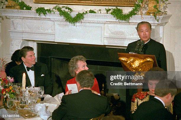 President Ronald Reagan enters with China's Premier Zhao Ziyang and First Lady Nancy Reagan , flanked by honor guards, a state dinner held at the...