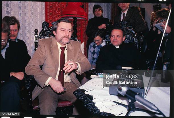 Nobel Peace Prize winner Lech Walesa sits at home and listens to the radio with Rev. Henryk Jankowski and others.