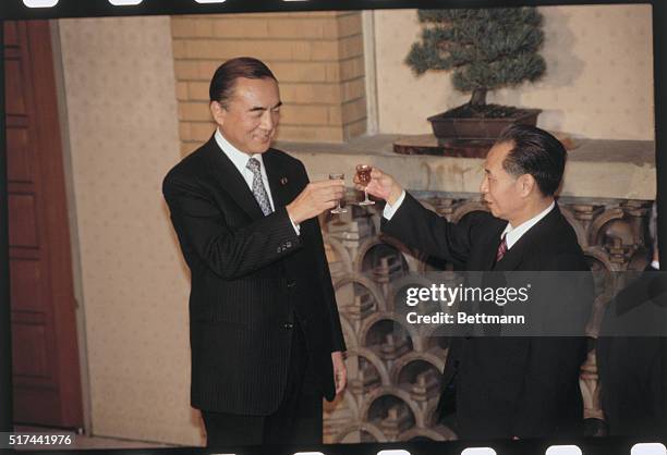 Tokyo, Japan: Chinese Communist Party General Secretary Hu Yaobang and Prime Minister Yashuhiro Nakasone toasting each other during a dinner party...