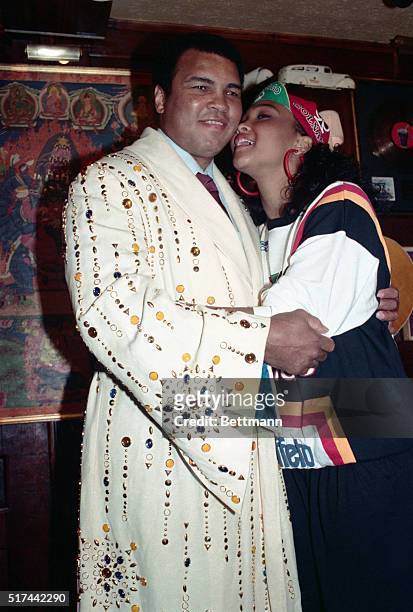 Boxing legend Muhammed Ali gets a kiss from his daughter May May after he donated the boxing robe he is wearing to the Hard Rock Cafe 5/12. The robe,...