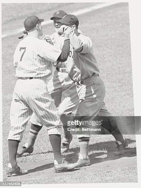 Bronx, New York: Jake Powell , Yankee left fielder is shown trading punches with pitcher Archie McKain and manager Joe Cronin of the Boston Red Sox...