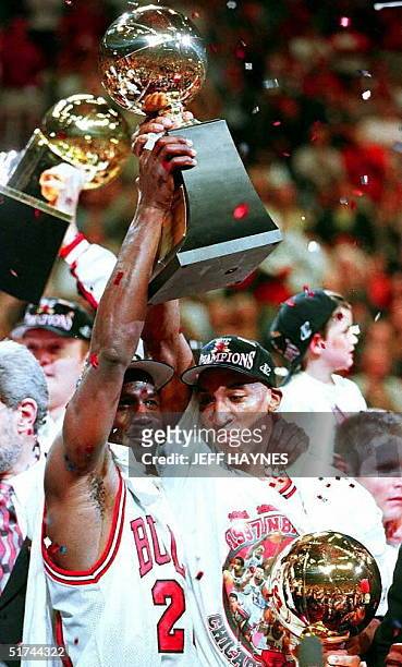 Michael Jordan holds the Larry O'Brien Trophy with teammate Scottie Pippen 13 June after game six of the 1997 NBA Finals at the United Center in...