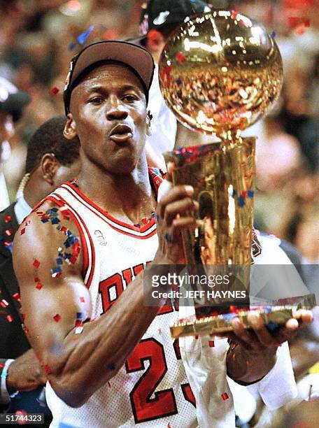 Michael Jordan of the Chicago Bulls holds the Larry O'Brien Trophy13 June after of game six of the 1997 NBA Finals at the United Center in Chicago,...
