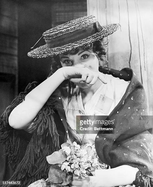 Julie Andrews as Eliza Doolittle in the stage musical "My Fair Lady." She is wiping her nose after crying.
