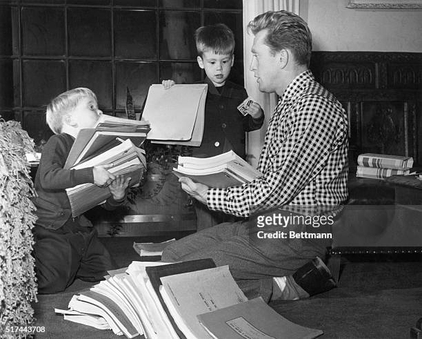 Actor Kirk Douglas sorts through scripts with his young sons, Michael and Joel.