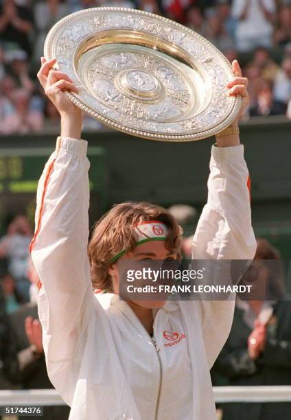 Swiss Martina Hingis lofts the winner's trophy after the Women's Singles final at the Wimbledon Championships. Hingis won the match, beating Czech...
