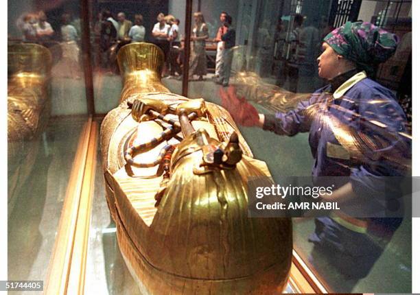An Egyptian worker cleans the glass case around the sarcophagus of Tutankhamun in the Egyptian Museum 30 November. Tickets sales at the world-famous...