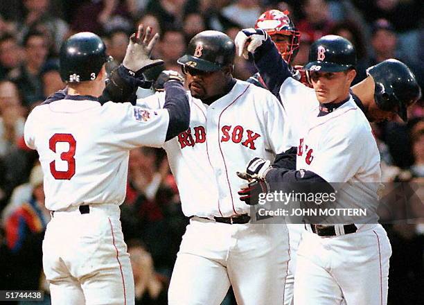 Boston Red Sox's Mo Vaughn is congratulated by team members Jeff Frye and Darren Bragg 16 April after hitting a thre-run homer in the fourth inning...