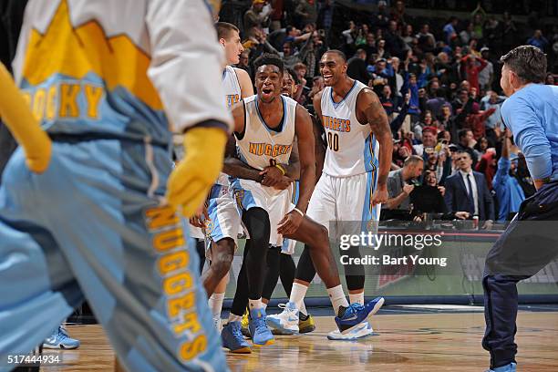 Emmanuel Mudiay of the Denver Nuggets celebrates with his teammates after hitting the game winning three point shot against the Philadelphia 76ers on...