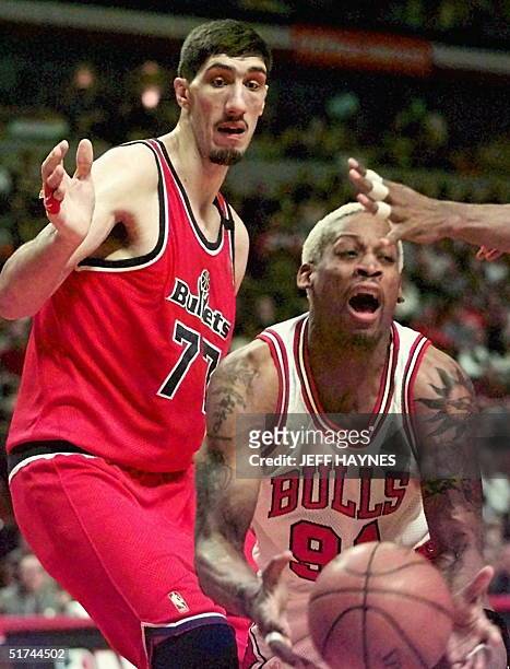 Dennis Rodman of the Chicago Bulls grabs a rebound away from Gheorghe Muresan of the Washington Bullets during the first half of game one of their...