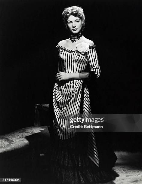 Lauren Bacall wears this off-the-shoulder period evening gown in a scene with Gary Cooper in the Warner Brothers production "Bright Leaf." The dress,...