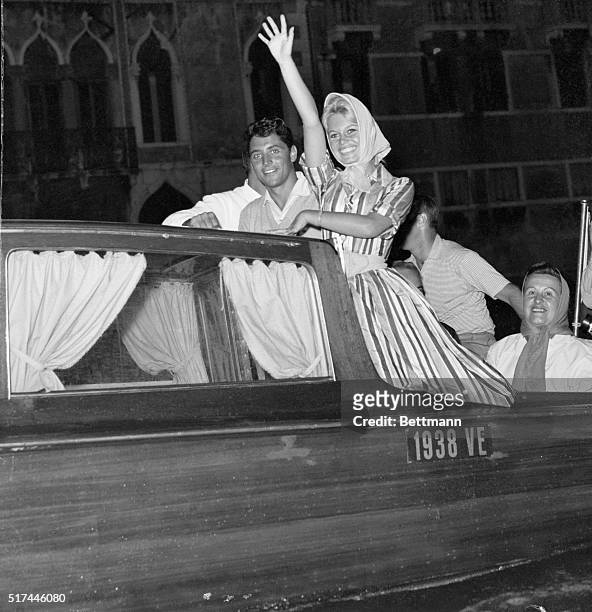 Venice, Italy- Glamourous French star Brigitte Bardot waves to cheering fans as she rides a motor launch along the Grand Canal accompanied by her...