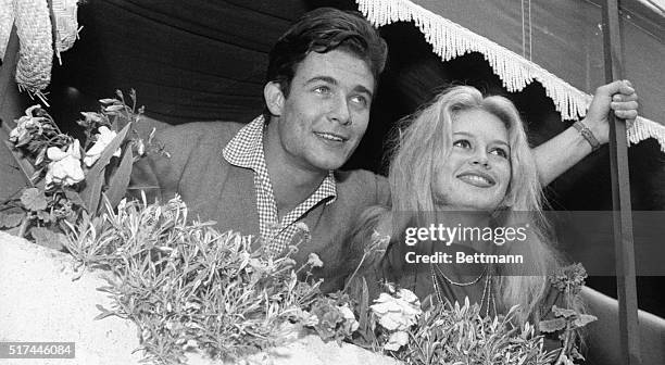 St. Tropez, France- Newlyweds Brigitte Bardot and Jacques Charrier look out from a balcony while on their honeymoon. The screen stars were wed June...