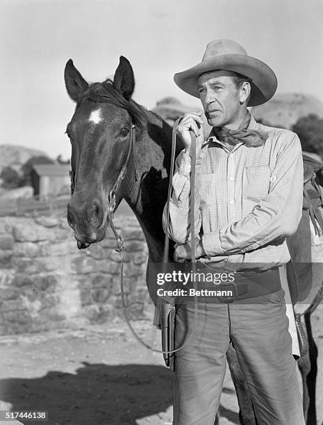 Gary Cooper stands alongside his horse in a scene from the 1945 comedic western Along Came Jones.