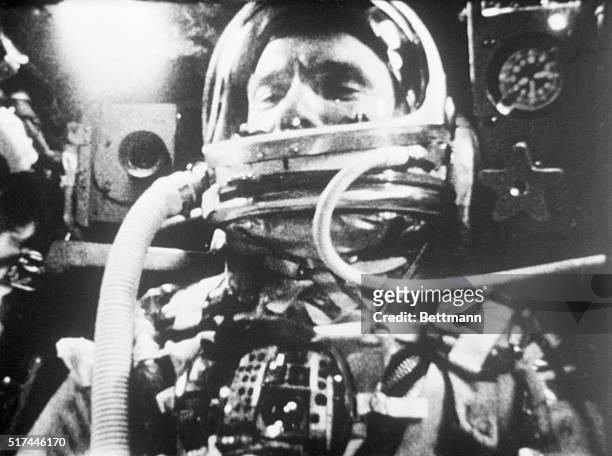Photograph of astronaut John Glenn inside the Friendship 7 space capsule as it orbits the Earth during the Mercury 6 mission