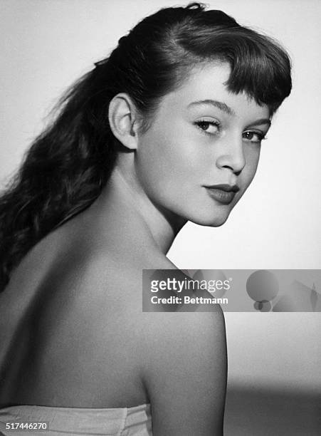Portrait of French actress Brigitte Bardot. She is shown wearing a strapless dress, looking back over her bare shoulder. Undated head and shoulders...
