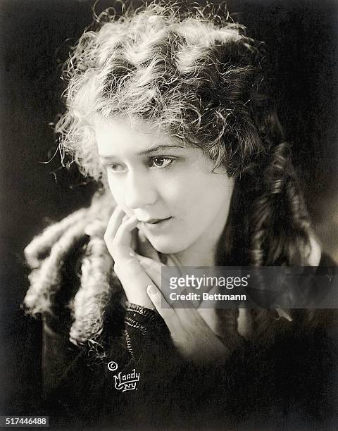 Well-known American silent film star Mary Pickford . Pickford is shown in a head-and-shoulders portrait, with her hands placed delicately near her...