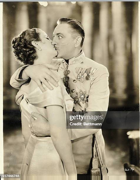 Actor John Barrymore kisses Diana Wynyard in a still from the film "Reunion in Vienna"), 1933. Barrymore is in the costume of a decorated military...