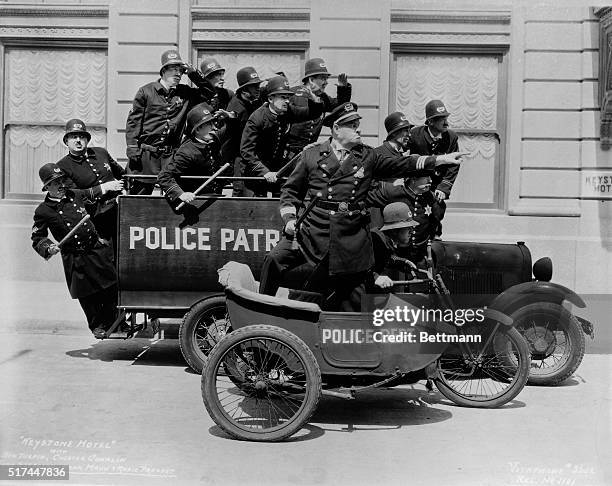 The Keystone Kops pile into a patrol wagon and motorcycle with side car in the 1935 film Keystone Hotel.