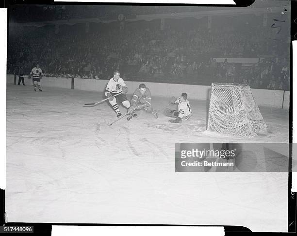 Henri Richard, , stumbles after taking a shot at Black Hawks' net in second period of game here. Hawk goalie Al Rollins, , turns the puck aside, as...