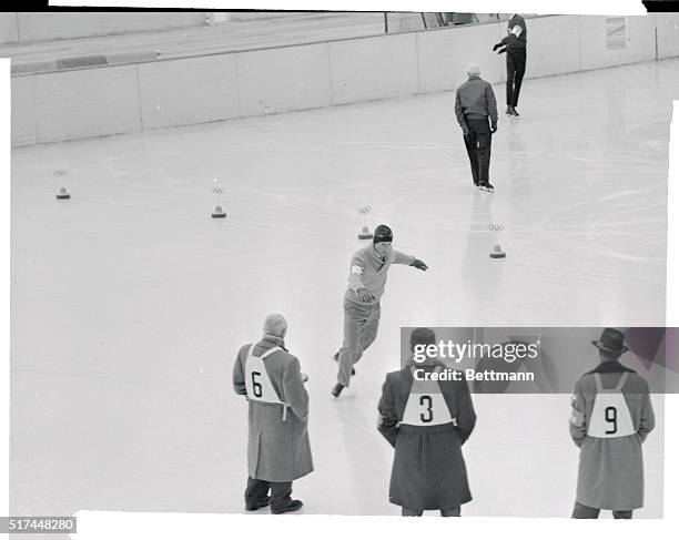 World figure skating champion Hayes Allen Jenkins glides gracefully over the ice doing compulsory figures, January 29th, while numbered judges Adolf...