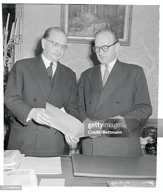 The French government changes hands as outgoing Premier Edgar Faure briefs his successor, Guy Mollet , in Paris. They were participating in handover...