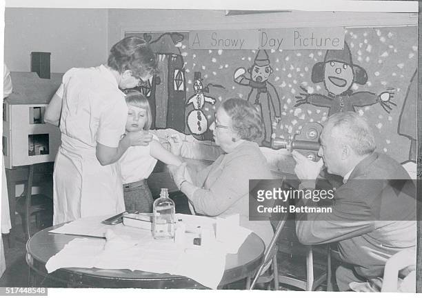 Lynn Stibbie receives an immunization shot for diphtheria in the Garfield School at Michigan City. Dr. Nelle Reed administers it with the aid of...