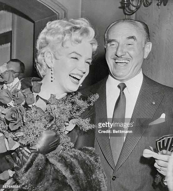 Actress Marilyn Monroe laughs heartily with Jack Warner, president of Warner Bros. Studios here, after Warner announced that Miss Monroe will co-star...