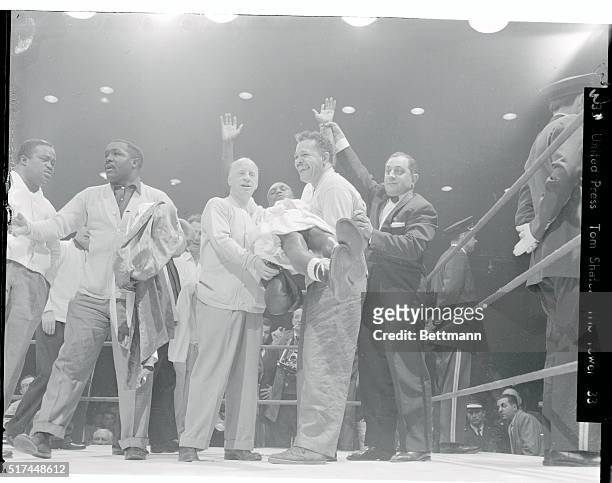 Johnny Saxton, the new welterweight champion of the world, is lifted off the floor by his jubilant handlers following his 15 round decision over...