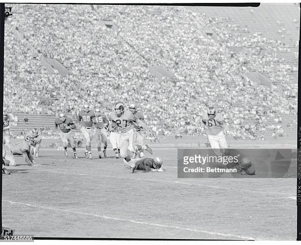 Ron Waller, Rams left halfback, gets out of the Lions den by going over a fallen Lion around right end for a gain of 14 yards in the 2nd quarter. The...