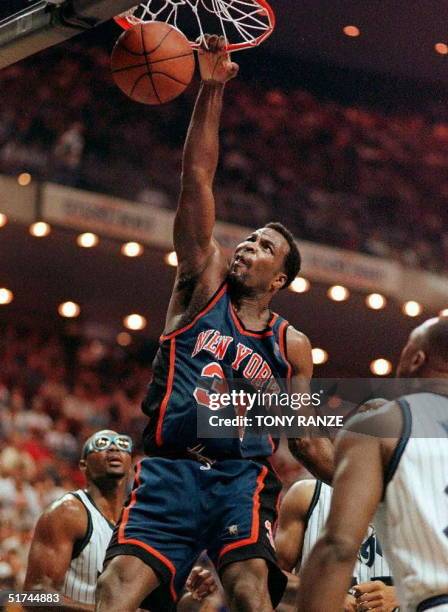 New York Knicks forward Charles Oakley slam dunks the ball after driving past Orlando Magic forward Horace Grant and guard Gerald Wilkins during the...