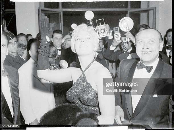 Speaking of beauty, Hollywood's Kim Novak shows plenty for photographers clustered around her. She's just finished work in The Eddy Duchin Story.