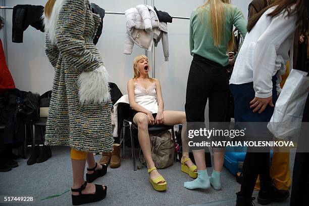 Model yawns as she awaits backstage before presenting creations by finalists of the Russian Silhouette young designers contest during the Fashion...