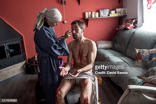 Concha makes up Felipe as he is dressing up as Jesus Christ ahead of the reenactment of Christ's suffering on March 25, 2016 in Hiendelaencina,...