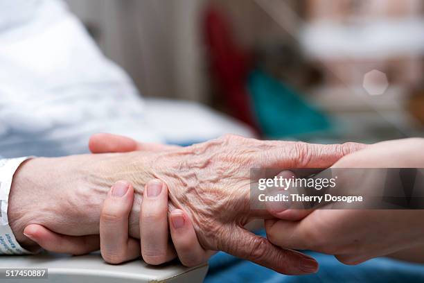 senior woman receiving hand massage - geriatría fotografías e imágenes de stock