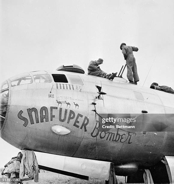 Gunners and mechanics work on the "Snafuper Bomber," one of the B-29 Superfortresses of the 20th Bomber Command, under the leadership of Major...