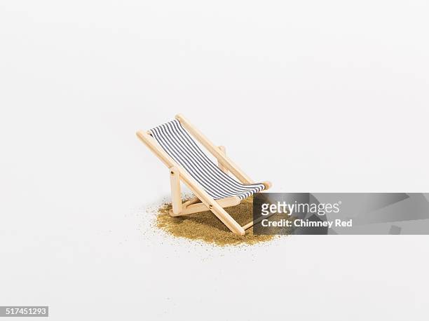 toy sunbathing chair on sand - deck chair stock pictures, royalty-free photos & images