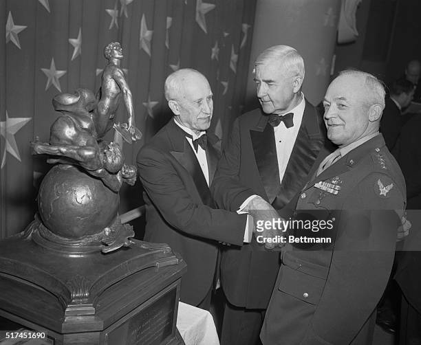 General Arnold Gets Collier Trophy. Washington, DC -- Clasping their hands in a three-way handshake Orville Wright and Secretary of Commerce Jesse...