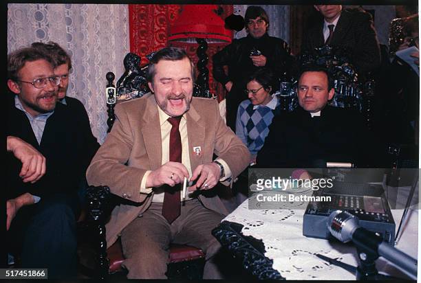Nobel Peace Prize winner Lech Walesa sits at home and listens to the radio with Rev. Henryk Jankowski and others. Lech Walesa has a big smile on his...