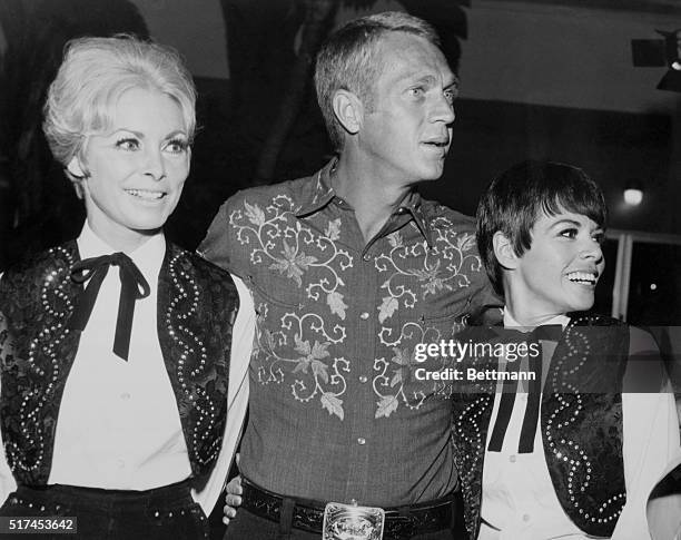 Candid Hollywood: Shades of the old west, pardners! Janet Leigh stops to chat with Steve McQueen and his wife Neile Adams. Business in cowboy and...