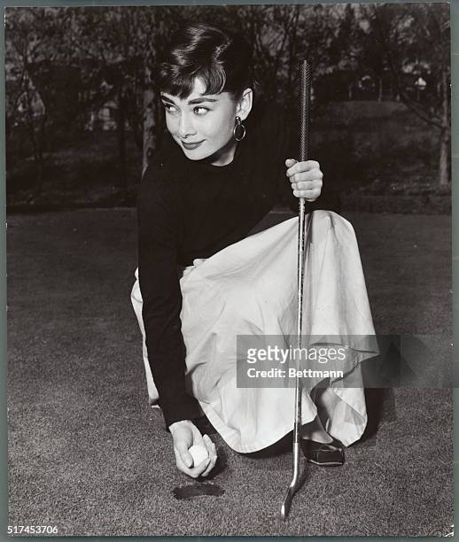 Audrey Hepburn 1929-1993. Audrey smiles after a successful putt. Undated photograph.