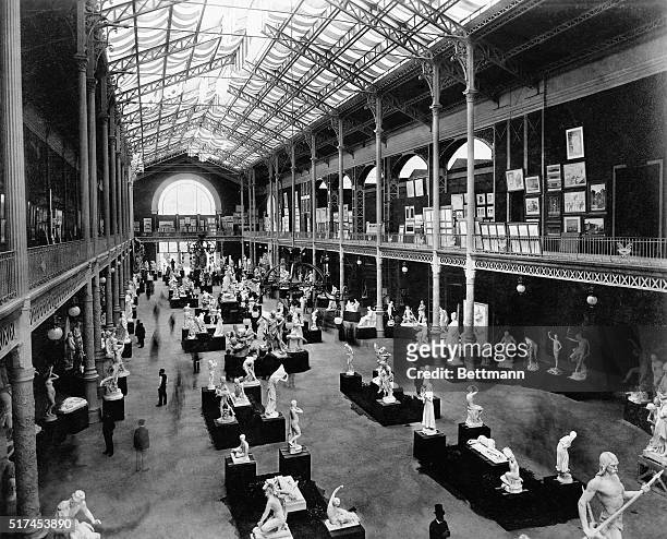Paris, France: Exposition Universelle view of length of art exhibition building; sculpture on ground floor, paintings on balcony. Undated photograph,...