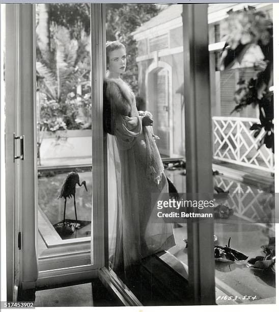 Ida Lupino plays leading role in Paramount's new film, "Yours For The Asking," She is seen by doorway in long nightgown holding a flower. Publicity...