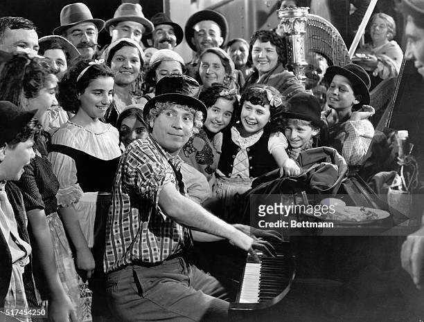 American comedian Harpo Marx, playing the piano in a scene from the Marx Brothers' comedy, 'A Night at the Opera', directed by Sam Wood, 1935....